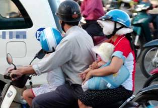 Cẩn thận với khăn cuốn người bé khi đi xe máy